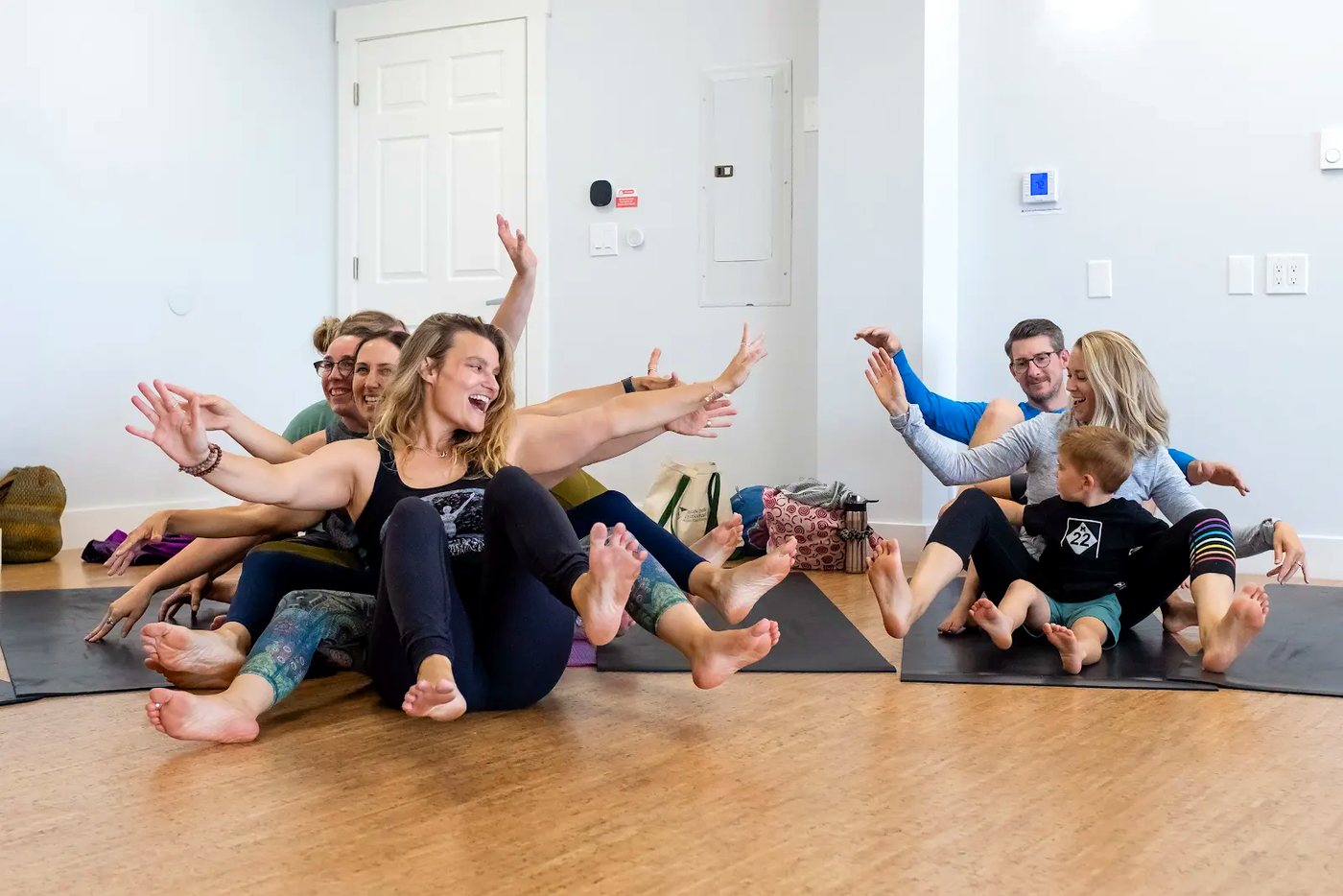 Adults smiling during a Rainbow Yoga group activity