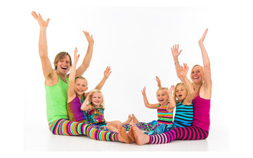 Adults and children sharing a playful seated movement activity in the Rainbow Yoga archive.