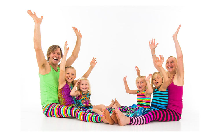 Adults and children sharing a playful seated movement activity in the Rainbow Yoga archive.