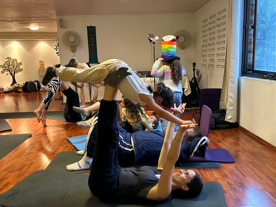 Niños y adultos practicando Rainbow Yoga juntos