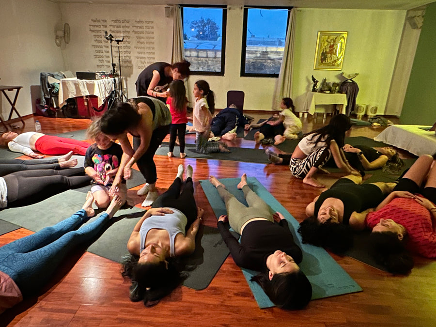 Práctica grupal Rainbow Yoga con estudiantes sonriendo y aprendiendo juntos
