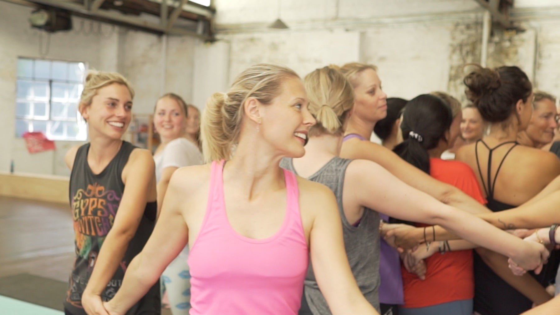 Adults smiling and connecting during a Rainbow Yoga training activity