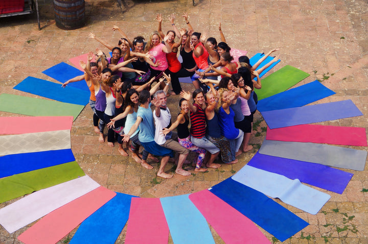 Rainbow Yoga trainees celebrating together in a colourful outdoor training circle