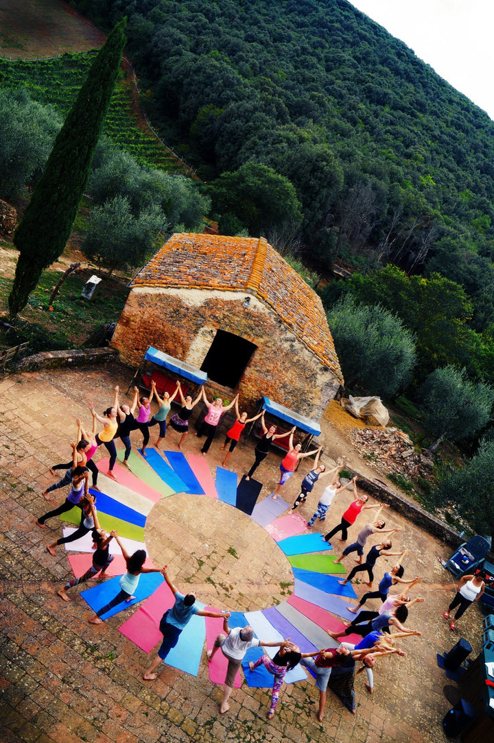 Rainbow Yoga trainees practising together in a colourful outdoor retreat circle
