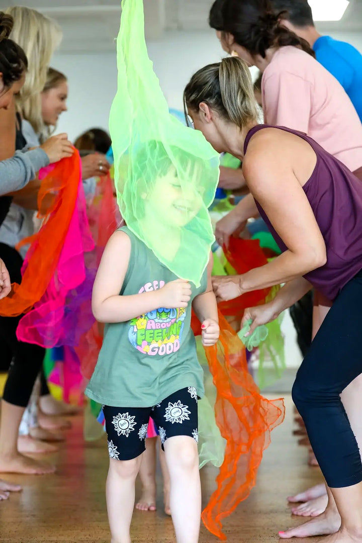 A smiling adult and child sharing a playful kids yoga moment